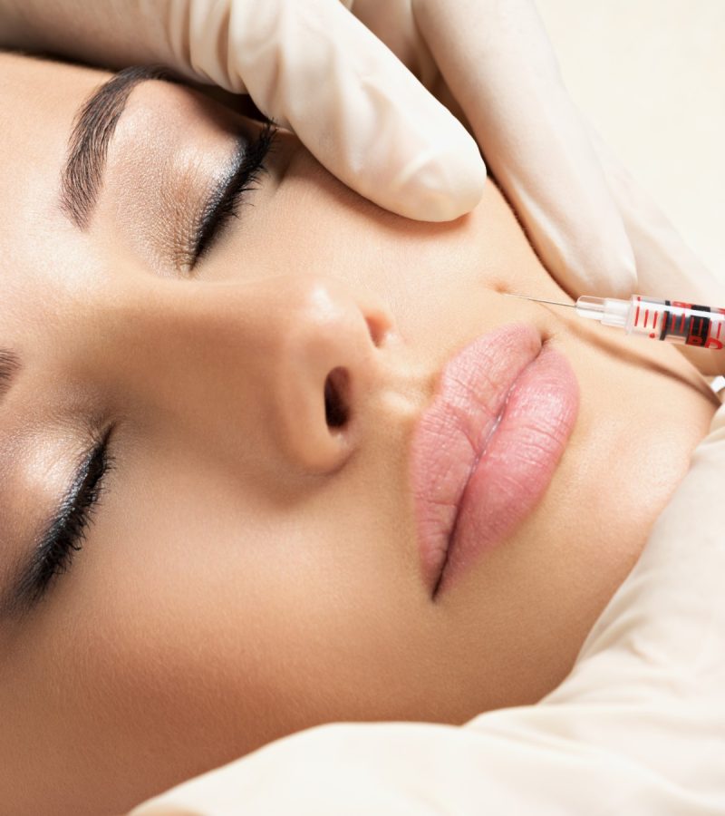 professional aesthetician injecting botox into a patient's face